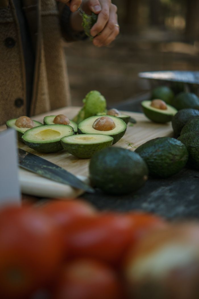 services-01 Sliced avocados being prepared outdoors, perfect for fresh guacamole recipes.