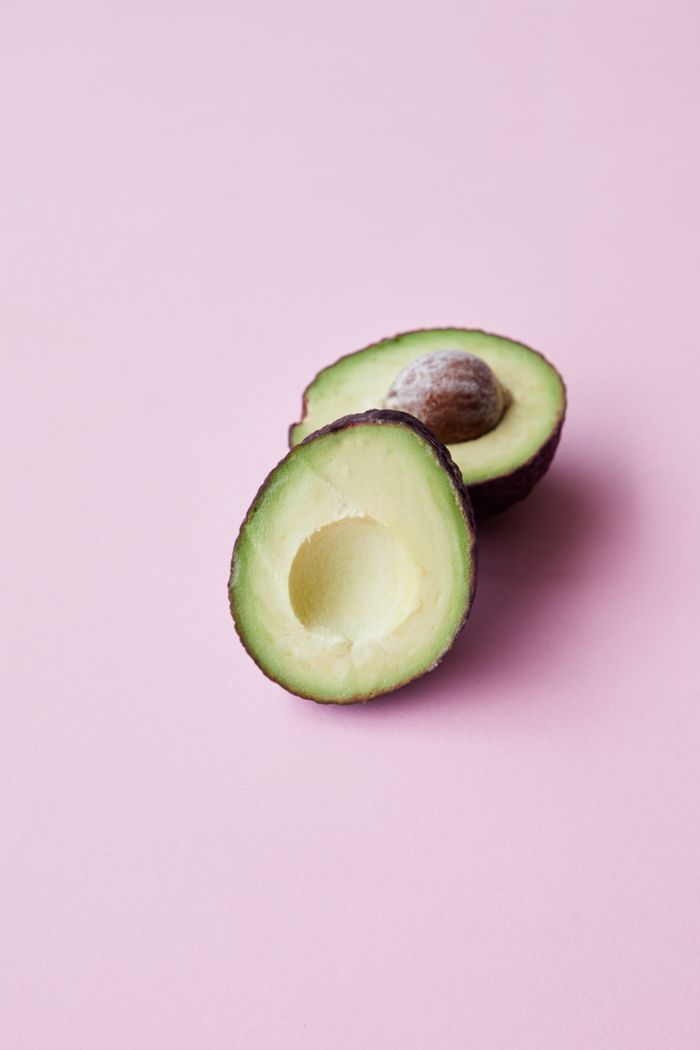 gallery-5 From above of ripe healthy halved avocado with seed placed on pink surface